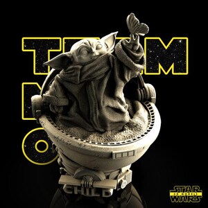 May include: A detailed 3D model of a character from Star Wars, holding a butterfly. The figure is seated in a pod, with the text "TEAM NO ONE" and "THE CHILD" visible. The background is black, with the Star Wars logo.