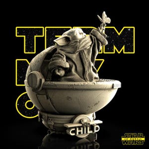 May include: A 3D model of The Child, also known as Baby Yoda, from Star Wars, seated in a pod. The figure is holding a butterfly. The words "TEAM BABY" are in yellow, and the words "THE CHILD" are on the pod.