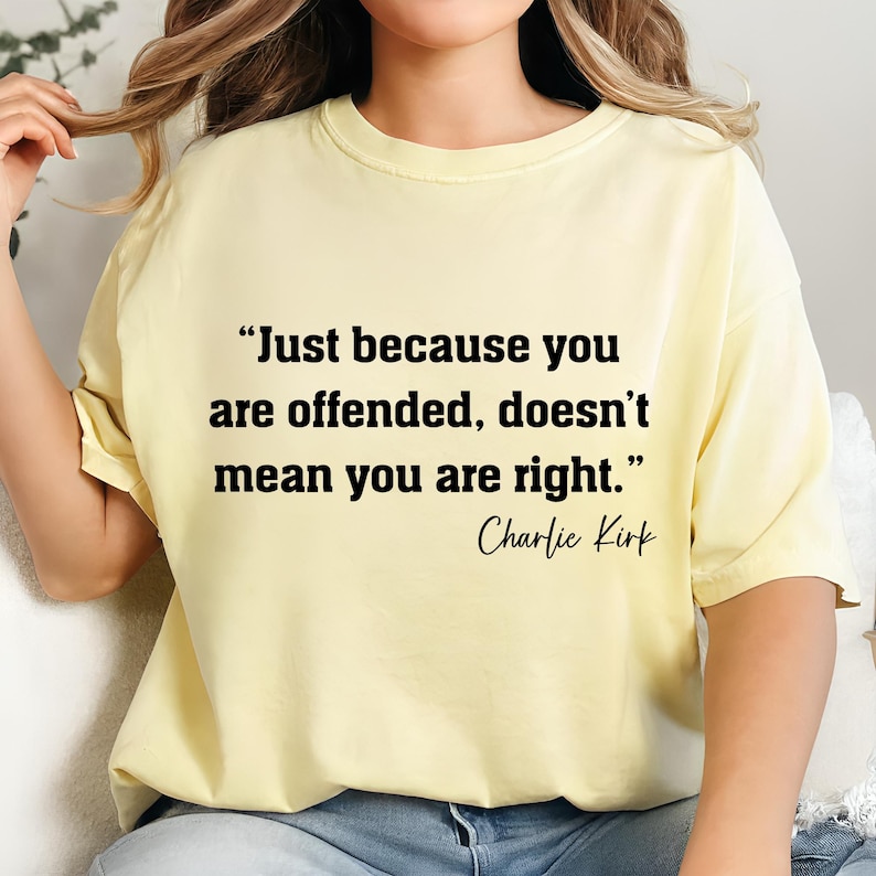 May include: A light yellow t-shirt with the quote "Just because you are offended, doesn't mean you are right." in black text. The quote is attributed to Charlie Kirk. The shirt is a casual style.