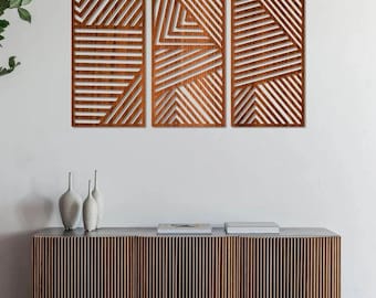 May include: A set of three rectangular wooden wall panels featuring intricate laser-cut geometric patterns of diagonal and horizontal lines. The panels are mounted side-by-side, showcasing a rich brown wood grain finish and open-work design.