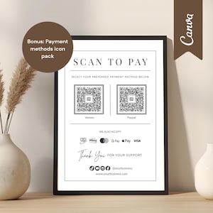 Puede incluir: Un letrero enmarcado en blanco y negro con el texto "SCAN TO PAY" y códigos QR para Venmo y PayPal. El letrero también enumera los métodos de pago aceptados e incluye un mensaje de "Gracias". Elementos decorativos: un jarrón con plantas secas y un jarrón blanco pequeño.