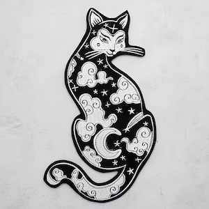 Può includere: Toppa ricamata in bianco e nero con design di gatto celeste. Il gatto è seduto con una luna crescente, nuvole e stelle. La toppa ha un design dettagliato ed è adatta per giacche, borse o altri oggetti in tessuto.