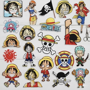 Könnte beinhalten: Eine Sammlung farbenfroher, gestickter Aufnäher mit Charakteren und Symbolen aus der Anime-Serie "One Piece". Die Aufnäher zeigen Bilder von Luffy, Zoro, Chopper und dem Jolly Roger.