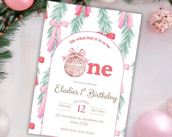 May include: A white invitation card with a pink and green Christmas theme. The card features the text "Oh what fun it is to be one" and "Elodie's 1st Birthday" with the date December 12. Pink bows and a Christmas ornament are also featured.