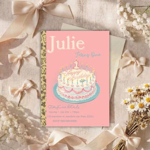 以下が含まれることがあります： Julie Turns Oneという文字と、ピンクのアイシング、キャンドル、数字の1のトッパーが飾られた白いケーキのイラストが中央に描かれた、長方形のピンク色の誕生日招待状。カードにはイベントの詳細を記載するスペースがあります。