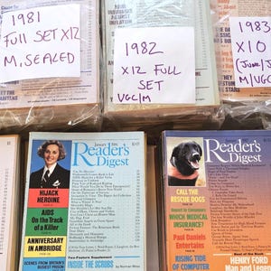 Könnte beinhalten: Eine Sammlung von Reader's Digest-Magazinen aus den 1980er Jahren, darunter Ausgaben von 1980, 1981, 1982 und 1983. Die Zeitschriften sind in verschiedenen Zuständen, einige versiegelt, mit handschriftlichen Etiketten.