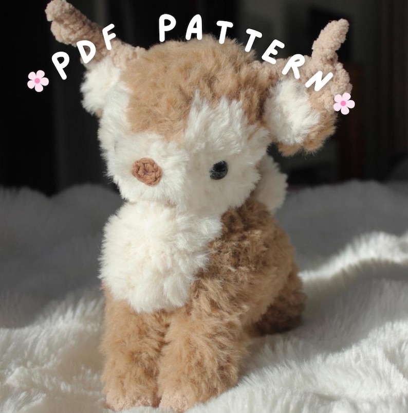 May include: A plush, handmade stuffed animal in the shape of a deer. The deer has a brown and cream color scheme with a fluffy texture. The text "PDF PATTERN" is visible in the image.