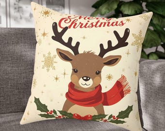 May include: Cream-colored decorative pillow with a cartoon reindeer wearing a red scarf. The pillow has the words "Merry Christmas" in red script, along with gold snowflakes and stars. Holly and berries are at the bottom.