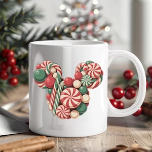 Puede incluir: Taza de cer&aacute;mica blanca con un dise&ntilde;o de cabeza de Mickey Mouse hecho de caramelos. El dise&ntilde;o incluye bastones de caramelo a rayas rojas y blancas, caramelos redondos verdes y rojos y caramelos en espiral rojos y blancos. Un tema festivo de vacaciones.