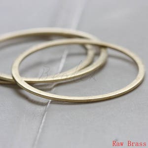 May include: Three brass rings of different sizes, stacked on top of each other. The rings are smooth and have a slightly textured surface. Raw Brass.