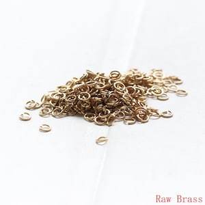Könnte beinhalten: Ein großer Haufen kleiner, goldfarbener Sprungringe. Die Ringe sind aus rohem Messing und perfekt für die Schmuckherstellung.