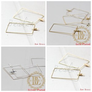 May include: Four pairs of rectangular wire hoop earrings in different finishes: raw brass, gold-plated, silver-plated, and raw brass. The earrings are all the same size and shape, but have different finishes.