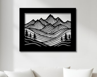May include: Black metal wall art depicting a mountain landscape with stylized peaks, rolling hills, and trees. The artwork is framed in a black square and mounted on a white wall. The design is minimalist and modern, suitable for home decor.