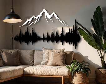 May include: A black and white metal wall art piece depicting a mountain range and forest silhouette. The artwork is mounted on a neutral-colored wall above a beige sofa with decorative pillows. A hanging lamp and potted plants are also visible.