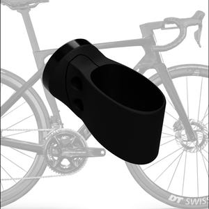 Peut inclure: Un collier de serrage de tige de selle de vélo noir mat présentant une forme ovale allongée et aérodynamique. Le composant comprend deux trous de boulon circulaires sur le côté pour une fixation sécurisée, avec une finition lisse et solide.