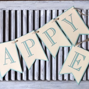 May include: A banner with the words "HAPPY EASTER" in blue letters on a cream background. The banner is decorated with a blue scalloped edge and a small image of a bunny rabbit with Easter eggs.