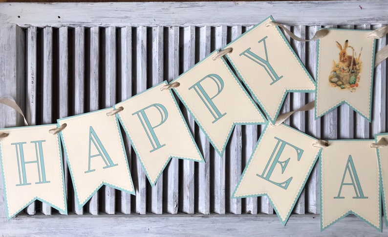 May include: A banner with the words "HAPPY EASTER" in blue letters on a cream background. The banner is decorated with a blue scalloped edge and a small image of a bunny rabbit with Easter eggs.
