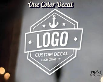 May include: A white vinyl decal featuring a hexagonal emblem with an anchor icon at the top, the word LOGO in the center, and the text CUSTOM DECAL and HIGH QUALITY below. The words One Color Decal appear at the top and Print chic at the bottom.