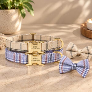 Può includere: Due collari per animali con motivi a quadri beige e blu, dotati di fibbie in metallo dorato incise con il nome Bella e il numero 123-456-7890. Due papillon abbinati a quadri beige e blu sono posizionati accanto ai collari.