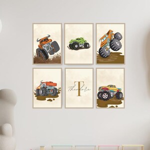 Pode incluir: Seis impressões emolduradas com ilustrações coloridas de monster trucks. Os caminhões são retratados em várias poses, com respingos de lama e um fundo neutro. Uma impressão apresenta o nome "Theodore".
