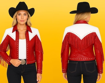 May include: A red and white leather jacket with fringe and stud details. The jacket is paired with a black cowboy hat and dark jeans. The jacket has a western style.