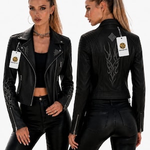 Puede incluir: Se muestran dos chaquetas de cuero negro con cremalleras plateadas y costuras decorativas. Las chaquetas tienen un estilo motero clásico con cremalleras asimétricas y cuello con solapas. La palabra "INDUSTRY" está en la etiqueta.