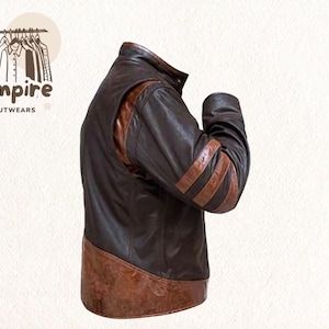 May include: A brown leather jacket with tan accents. The jacket features a stand-up collar, shoulder panels, and three tan stripes on the sleeves. The jacket has a two-tone design and is from Empire Outwears.