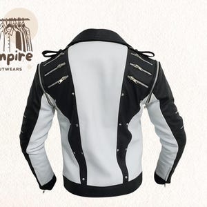 Pode incluir: Casaco de couro preto e branco com z&iacute;peres e tachas prateadas. O casaco tem um estilo motociclista cl&aacute;ssico com gola de lapela e fecho de z&iacute;per assim&eacute;trico. As mangas s&atilde;o pretas e o corpo branco com detalhes pretos. Empire Outwears.