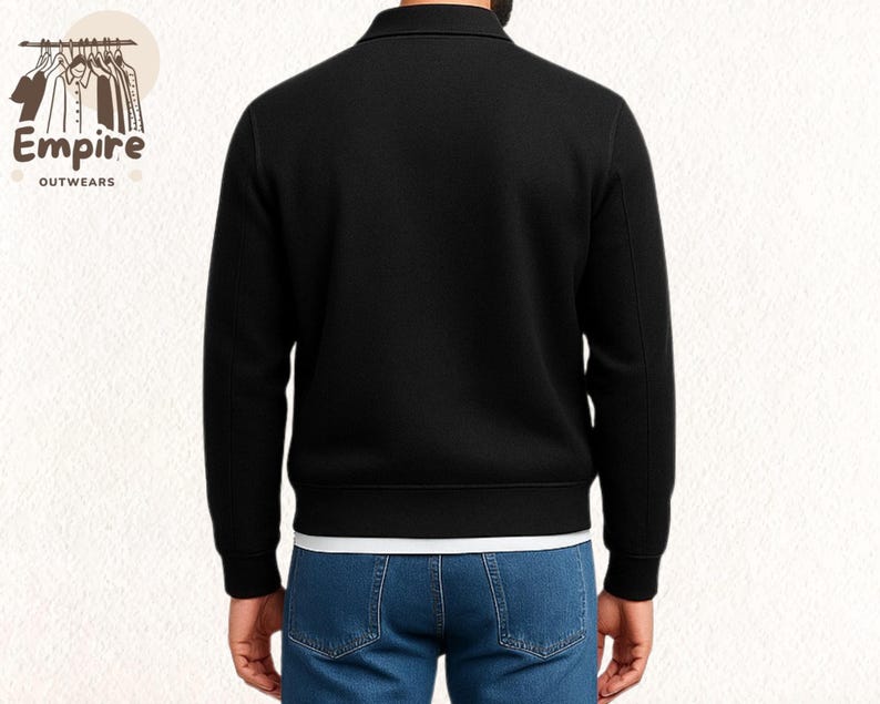 Pode incluir: Casaco preto com z&iacute;per e gola. Usado sobre uma camiseta branca e jeans azuis. O logotipo "Empire Outwears" &eacute; vis&iacute;vel no canto superior esquerdo.