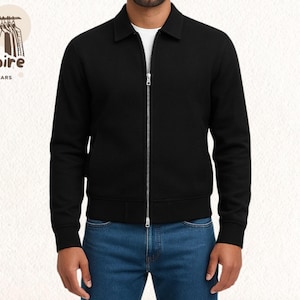 May include: A black zip-up jacket with a collar. The jacket has a silver zipper and is worn over a white t-shirt and blue jeans. The logo "Empire Outwears" is in the upper left corner.