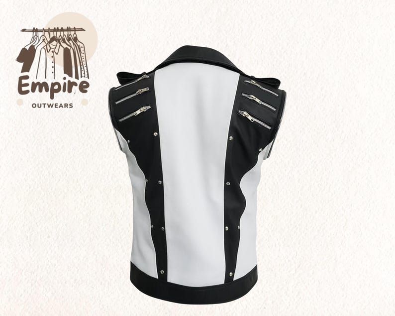 Pode incluir: Um colete sem mangas preto e branco com z&iacute;peres e tachas prateadas. O colete tem gola e acabamentos pretos, com um painel central branco. O logotipo da marca "Empire Outwears" est&aacute; no canto superior esquerdo. Uma pe&ccedil;a de vestu&aacute;rio elegante.