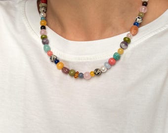 Peut inclure: Un collier de perles composé d'une variété de pierres et de perles multicolores aux formes diverses. Le rang comprend du jaspe dalmatien, du quartz rose, de l'améthyste, de la turquoise et des perles jaunes, créant un agencement vibrant et éclectique.