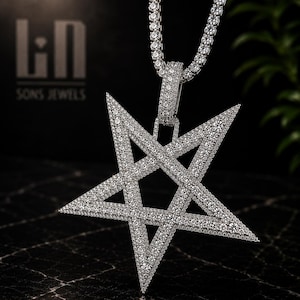 May include: A silver-toned star-shaped pendant covered in small clear stones, suspended from a matching tennis chain. The pendant features a five-pointed star design with a central cutout. The text "LN SONS JEWELS" is visible in the background.