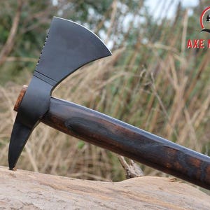 Pode incluir: Machado com uma cabe&ccedil;a preta fosca escura e um cabo de madeira. A cabe&ccedil;a do machado tem uma l&acirc;mina curva e uma ponta no lado oposto. O cabo &eacute; marrom escuro com gr&atilde;o de madeira vis&iacute;vel. O texto "AXE MASTER" &eacute; vis&iacute;vel.