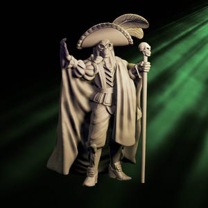 May include: A detailed sculpture of a skeletal figure in a wide-brimmed hat adorned with feathers, a cape, and a staff topped with a skull. The figure is in a regal pose, with one arm raised. The color is a muted beige.