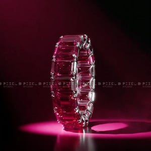 Peut inclure: Un bracelet rose vif orné de pierres précieuses rectangulaires et d'accents métalliques argentés. Le bracelet est présenté sur un fond rouge foncé avec un effet de projecteur, créant une présentation dramatique. Les pierres précieuses reflètent la lumière.