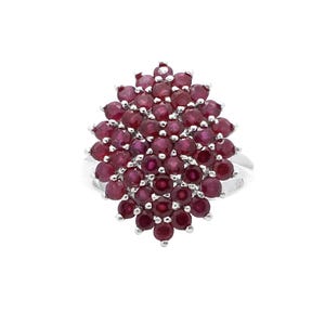 Può includere: Un anello d'argento con un grappolo di piccole gemme rotonde di colore rosso intenso. Le gemme sono fittamente raggruppate, creando un design ovale strutturato. La fascia dell'anello è in argento lucido.