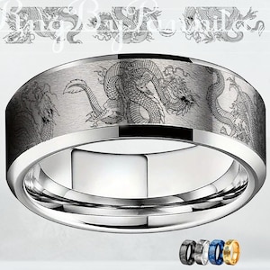 May include: A silver-colored ring with a brushed metal finish, featuring an engraved dragon design around the band. The ring has a polished inner surface and a selection of alternative color options are shown at the bottom.