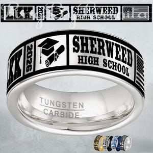 May include: A silver tungsten carbide ring with black lettering and accents. The ring features the text "SHERWEED HIGH SCHOOL" and "2026", along with a graduation cap and diploma graphic. The ring also has an American flag design.