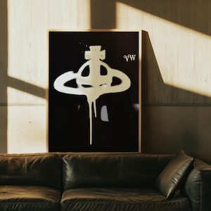 May include: A framed art print featuring a white graphic on a black background. The graphic appears to be a stylized orb with a cross on top and dripping paint effect. The letters "VW" are in the upper right corner.
