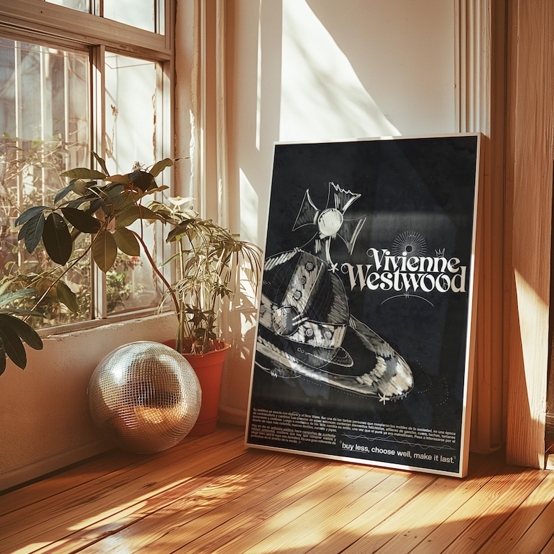 May include: A framed black poster with the Vivienne Westwood logo and a planet graphic with a crown. The poster is propped against a wall near a window and a potted plant. The text "buy less, choose well, make it last" is at the bottom.