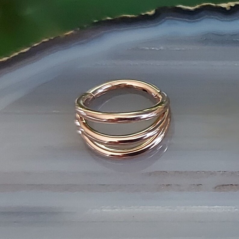May include: Rose gold seamless ring with three stacked bands.
