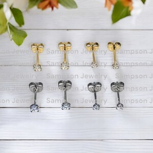 May include: Six pairs of stud earrings with a small clear stone in the centre. Three pairs are gold and three pairs are silver.