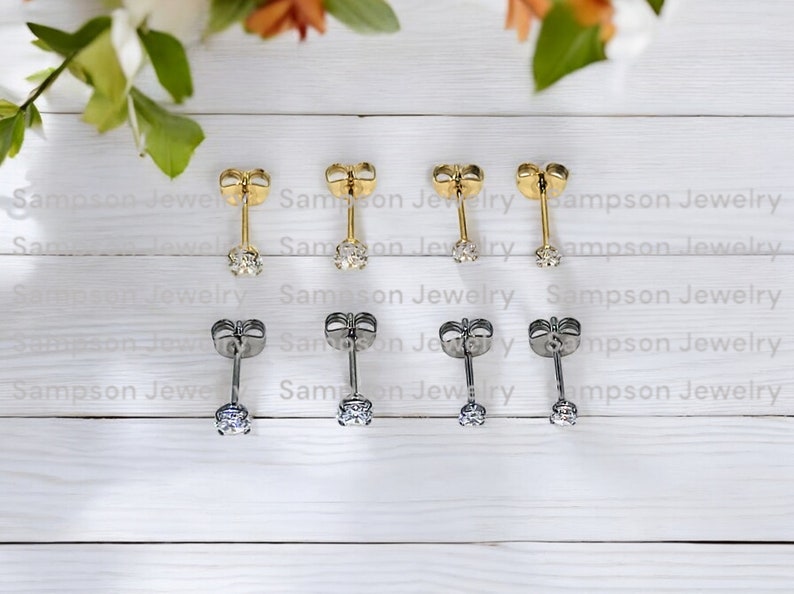 May include: Six pairs of stud earrings with a small clear stone in the centre. Three pairs are gold and three pairs are silver.