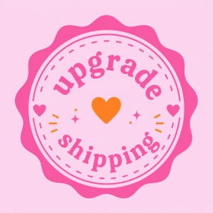 May include: A pink and orange badge with the words "upgrade shipping" in a circular design. The badge has a scalloped edge and a heart in the center. Additional hearts and starbursts are included in the design.