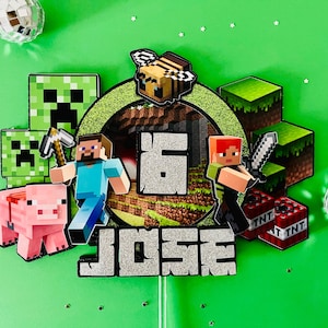 May include: A Minecraft-themed birthday cake topper with the name "JOSE" and the number "6". The design includes pixelated characters, blocks, a pig, a bee, and TNT blocks, all set against a green background.