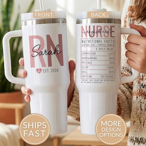 May include: A white stainless steel tumbler with a handle and straw. The front features the text RN, Sarah, and EST. 2026 with a heart icon. The back displays a nutritional facts label for a nurse, including text like Compassion and Caffeine.