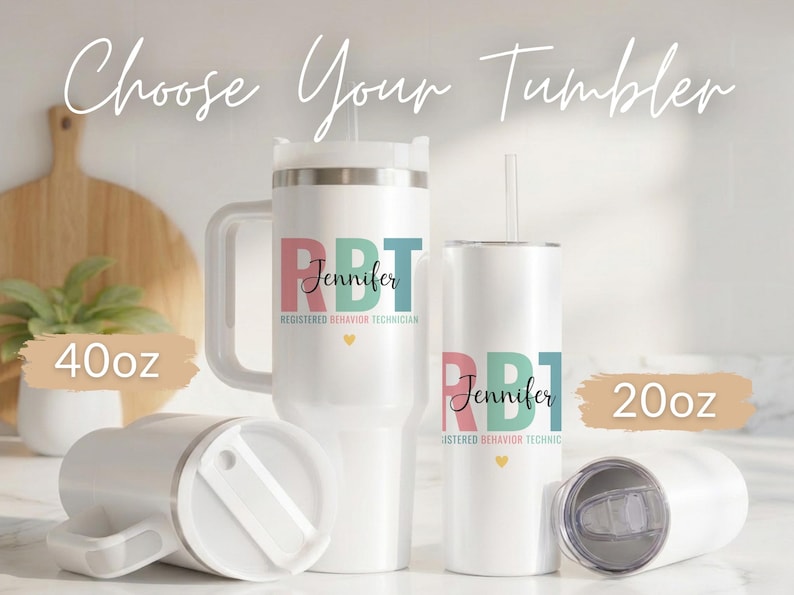 Pode incluir: Canecas brancas com texto personalizado, incluindo uma caneca de 1183 ml com al&ccedil;a e uma caneca de 591 ml. As canecas apresentam o texto "RBT Jennifer Registered Behavior Technician" em rosa, azul-petr&oacute;leo e preto, com um pequeno cora&ccedil;&atilde;o amarelo.