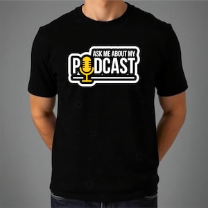 Puede incluir: Una camiseta negra de manga corta con un gráfico en el pecho que incluye el texto blanco "ASK ME ABOUT MY" sobre la palabra "PODCAST" en blanco, con un icono de micrófono amarillo que sustituye a la letra "O" en "PODCAST".