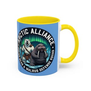Puede incluir: Taza de cerámica con interior y asa amarillos, exterior azul con las palabras "Arctic Alliance Polar Bear & Walrus Defense Squad". El diseño incluye una ilustración de oso polar y morsa.